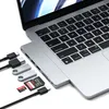 A Satechi Pro Hub Slim is connected to a laptop, with various accessories like USB drives and SD cards plugged into it. Produktbild-Vorschau