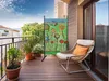 A decorative screen with a floral design stands on a wooden balcony next to a wicker chair. Produktbild-Vorschau