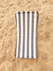 A striped beach chair lying on the sand. Produktbild-Vorschau