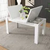 A white dining table with its top panels lifted to reveal storage compartments, set in a room with a rug and artwork. Anteprima dell’immagine prodotto