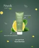 A tube of Niyok toothpaste is shown with lemon and mint leaves, against a dark green background with scattered lemon slices and mint leaves. Anteprima dell’immagine prodotto