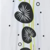A close-up view of a white fabric with a repeating pattern of black lily pads and thin yellow lines. Anteprima dell’immagine prodotto