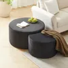 Two round ottomans are placed in a living room setting next to a sofa. One ottoman is larger and has a book and a bowl of grapes on it. The smaller ottoman has a brown blanket draped over it. Produktbild-Vorschau