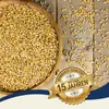 A bowl of grain is shown next to scattered grains on a wooden surface, with a marketing badge overlay. Produktbild-Vorschau