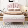 A pink upholstered bed with a shell-shaped headboard and golden legs, set in a bedroom with nightstands and decor. Produktbild-Vorschau