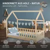A wooden children's bed with a house-like frame, set up in a room with other furniture and decor. Produktbild-Vorschau