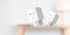 Two white smart plugs are shown floating against a blurred background of a room. Voir les images du produit