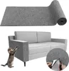 A rolled-up piece of grey felt material is shown above a grey sofa. A cat is shown on the left, reaching up towards the sofa armrest. A close-up inset shows hands cutting the felt material with scissors. Produktbild-Vorschau