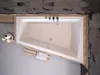 A top-down view of a modern bathtub with wooden accents. Produktbild-Vorschau