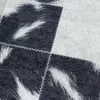 A close-up view of a patchwork rug with a cowhide pattern. Produktbild-Vorschau