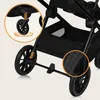 Close-up view of the wheels and storage basket of a black stroller. Produktbild-Vorschau