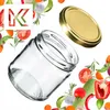 A clear glass jar with a gold lid, surrounded by fresh vegetables and herbs. Produktbild-Vorschau
