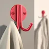 A red wall hook with a light-colored towel draped over it. Produktbild-Vorschau