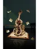 A mechanical cello model is displayed on a book with sheet music floating around it. Náhľad obrázku produktu