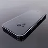 A black smartphone with water droplets on its screen, placed on a reflective dark surface. Anteprima dell’immagine prodotto