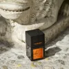 A perfume bottle is placed on a stone surface in front of a stone sculpture. Anteprima dell’immagine prodotto