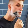 A man is shaving his face with a razor. Anteprima dell’immagine prodotto