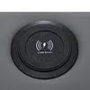 A close-up view of a wireless charging pad with USB output integrated into a gray upholstered surface. Náhled obrázku produktu