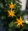 Three yellow star-shaped lights are attached to a green artificial Christmas tree garland. Produktbild-Vorschau