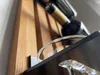 A close-up shot of a wooden wine rack with bottles and glasses. Produktbild-Vorschau