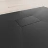A close-up view of a black shower tray with a rectangular drain cover. Produktbild-Vorschau