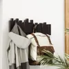 A dark brown wall-mounted coat rack with five movable hooks, holding a gray jacket and a cream and brown backpack. Náhľad obrázku produktu