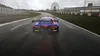 A racing car on a wet track with a Ferris wheel in the background. Produktbild-Vorschau
