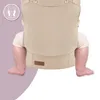 A close-up of a baby in a beige baby carrier, showing the legs and part of the carrier. Náhled obrázku produktu
