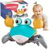 A baby is crawling towards a toy crab, with the toy's packaging in the background. Produktbild-Vorschau