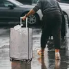 A person is pulling a suitcase on a wet street. Anteprima dell’immagine prodotto