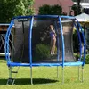 A young girl is jumping on a trampoline in a backyard. Podgląd zdjęcia produktu