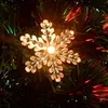 A close-up of a snowflake-shaped LED light on a Christmas tree. Voir les images du produit
