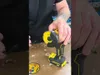 A person is holding a cordless angle grinder with a cutting disc attached, with another cutting disc visible on the surface. Produktbild-Vorschau