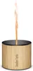A Stadler Form aroma diffuser with a bamboo casing and aluminum lid, emitting a flame-like vapor. Produktbild-Vorschau