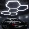 A black car is parked in a garage with hexagonal LED lights on the ceiling. Náhled obrázku produktu