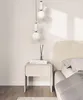A bedside table with books and a diffuser next to a bed. Anteprima dell’immagine prodotto