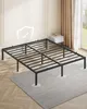A metal bed frame with white circular feet pads sits on a gray rug in a room with light-colored walls and sheer curtains. Produktbild-Vorschau
