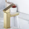 A gold-colored bathroom faucet with water running into a sink. Náhľad obrázku produktu