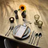 A table setting with a sunflower, candle, salt and pepper shakers, cutlery, glasses, and a menu on a clipboard. Podgląd zdjęcia produktu