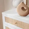 Close-up of a white dresser with rattan drawer fronts and decorative vases on top. Produktbild-Vorschau