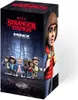 A box of Stranger Things Minix collectible figurines with a forest background and a character on the side. Podgląd zdjęcia produktu