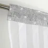 A close-up view of the top of a white sheer curtain with a decorative silver band along the top edge, hanging from a metal curtain rod. Podgląd zdjęcia produktu