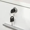 A close-up of a white filing cabinet with a key in the lock and a drawer handle. Produktbild-Vorschau