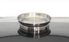 A stainless steel pan sits on a black reflective surface, likely a stovetop. Produktbild-Vorschau