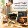 A man is preparing food with a Cosori air fryer in the background, with labels indicating different dishes. Produktbild-Vorschau