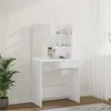 A white vanity table with a mirror and shelves, decorated with makeup brushes and bottles, is shown in a room with a plant and curtains. Voir les images du produit