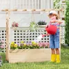 A young child watering flowers in a wooden planter box with a trellis. Anteprima dell’immagine prodotto