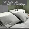 A bed with pillows and a bedside table with candles. Náhled obrázku produktu