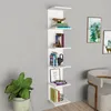 A white, multi-tiered shelf unit is mounted on a light gray wall, displaying various books and decorative items. A potted green plant is visible to the left, and a chair is partially visible to the right. Náhľad obrázku produktu