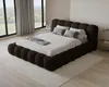 A bedroom with a large bed, large windows with curtains, and a rug. Voir les images du produit